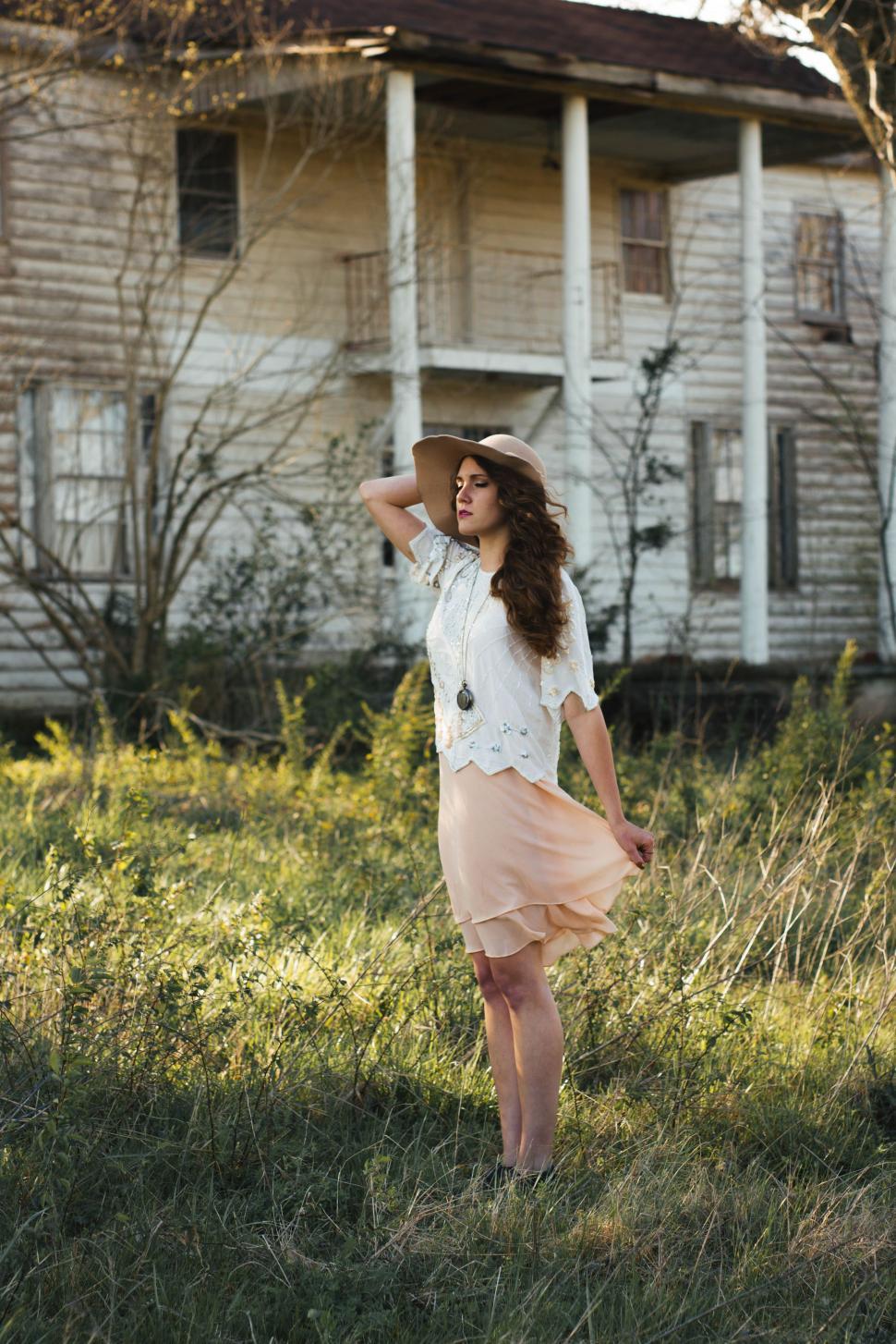 Free Image of Woman in hat standing on grass  