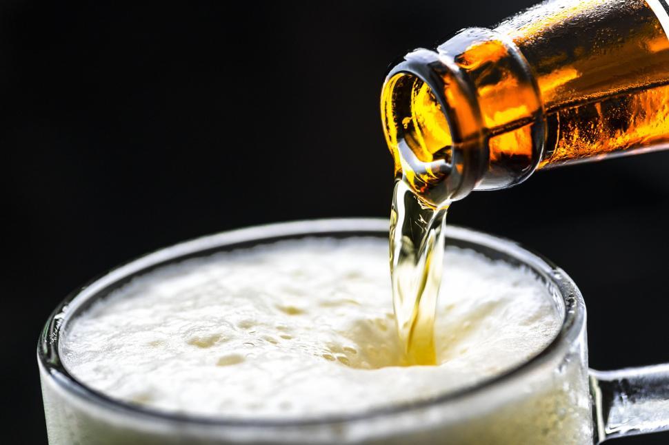 Free Image of Beer frothing while being poured into a pint mug 