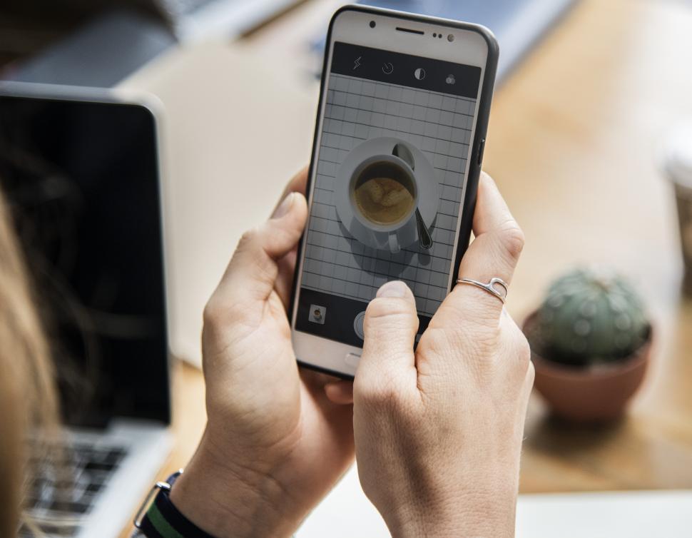 Free Image of Close up of a smart phone in a persons hands, viewing coffee 