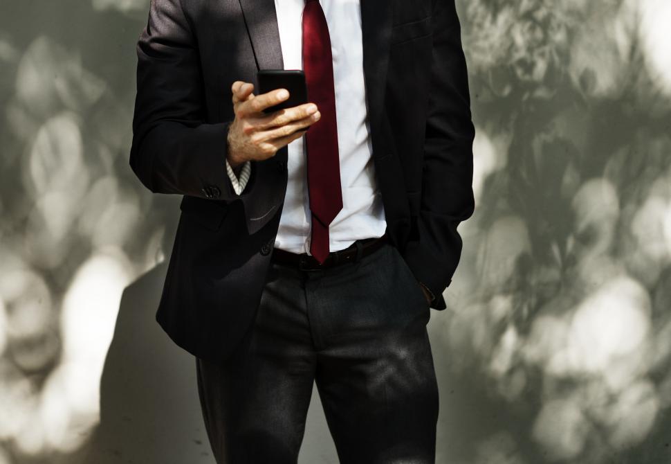 Free Image of Anonymous man looking at his mobile phone 