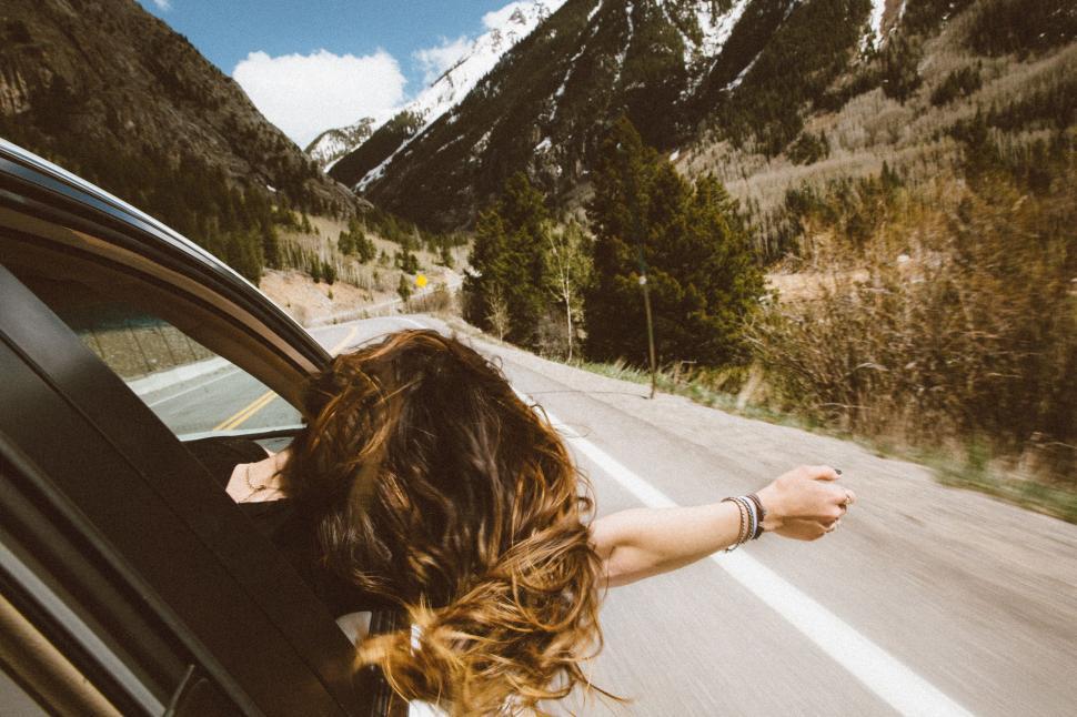Free Image of Back Side View of Woman in Car with Hand out  