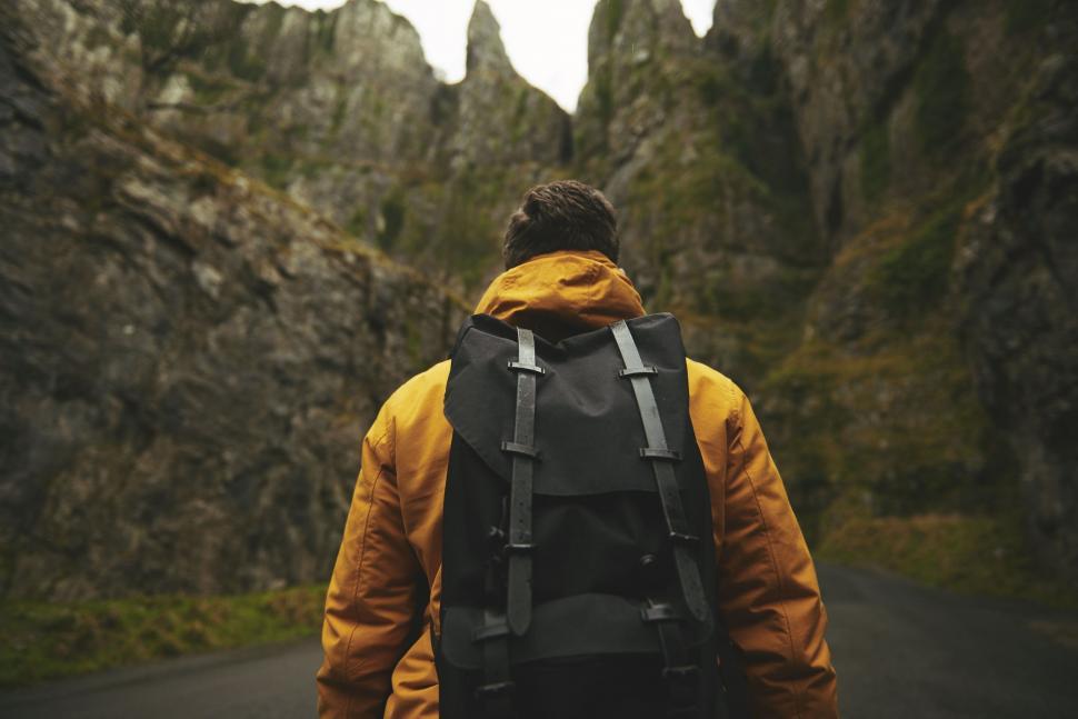 Free Image of Back Side view of Hiker on mountain road  