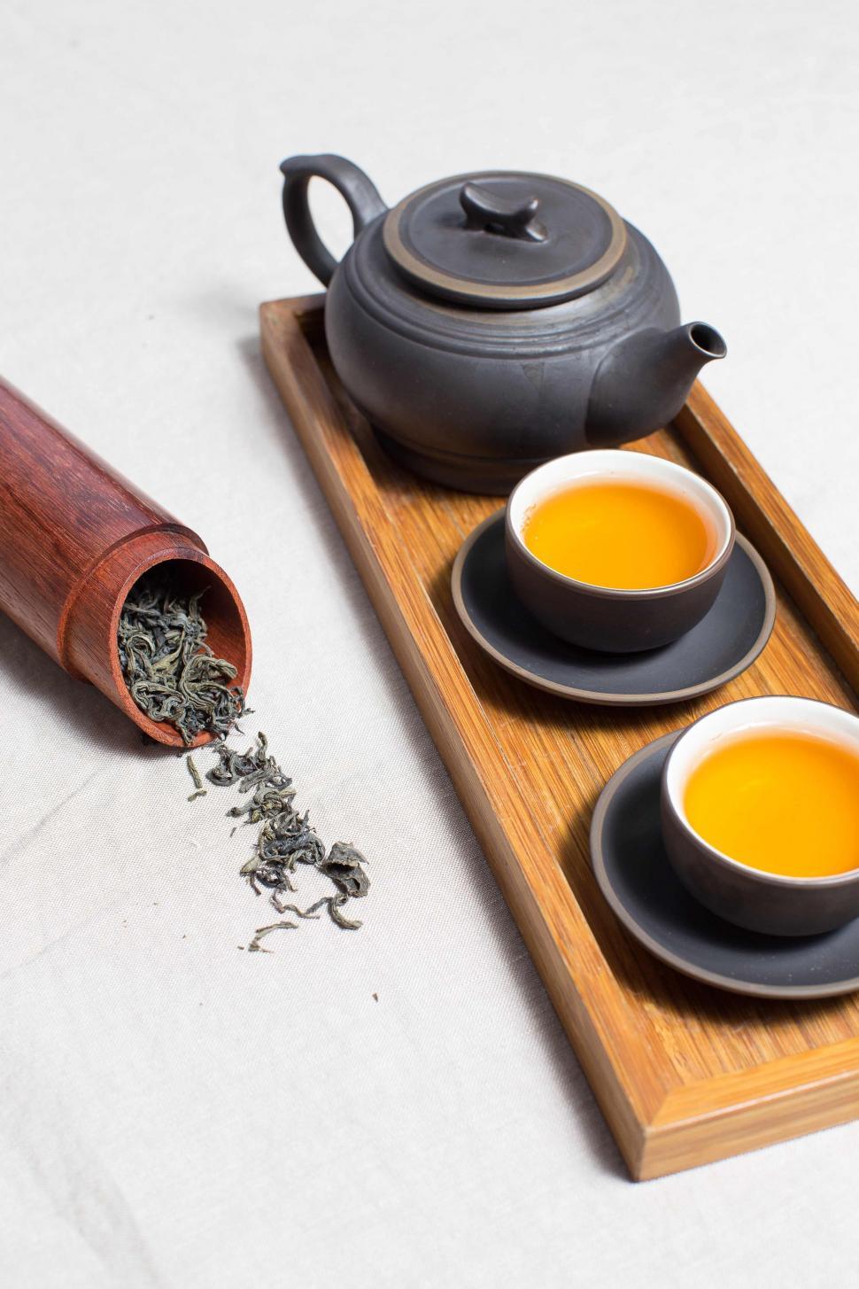 Free Image of Tea cups and Kettle with dried tea leaves  