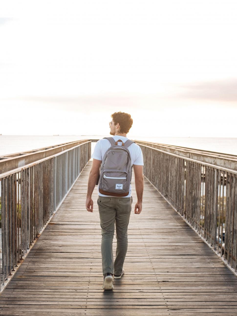Free Image of Back side view of man walking on pier  