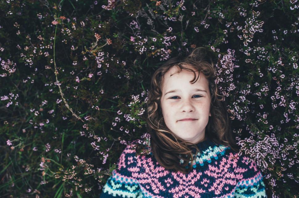 Free Image of Young Girl lying on her back - looking up to the camera 
