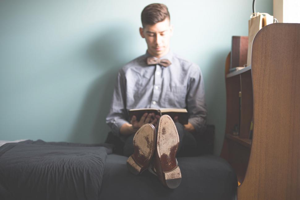 Free Image of Young Boy Reading on Bed  