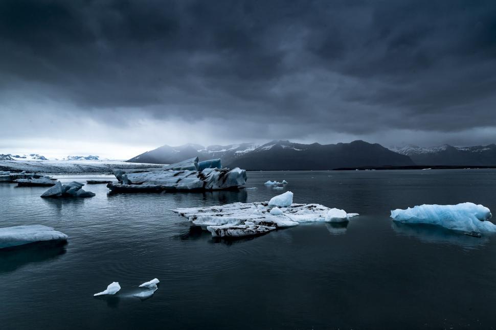 Free Image of Glacier and iceberg with dark clouds  