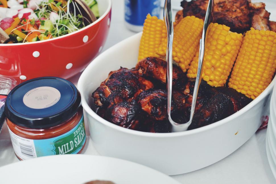 Free Image of Corn cob and grilled meat with sauce jar 