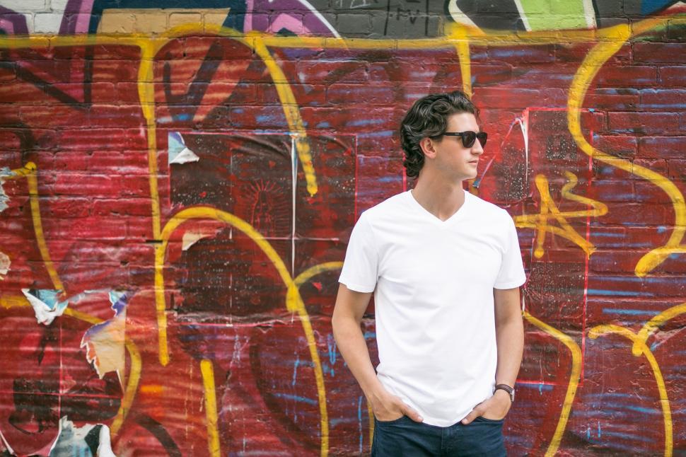 Free Image of Caucasian Man in White T-shirt with hands in pockets 