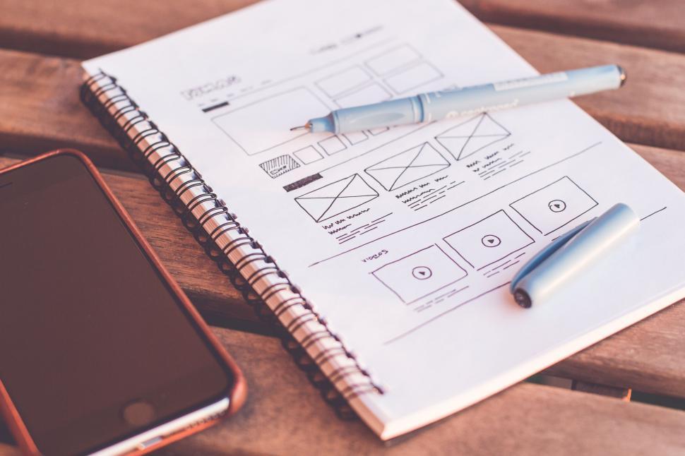 Free Image of iPhone and Notebook on wooden table  