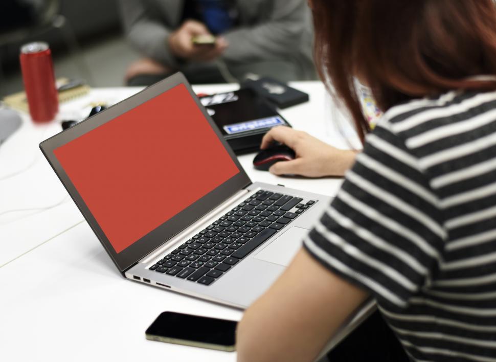 Free Image of A young woman working on her laptop, blank screen ready for content 