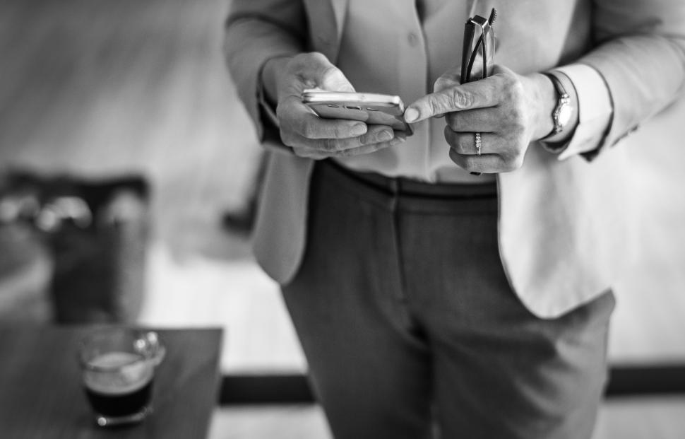 Free Image of Black and white of hands holding mobile phone 