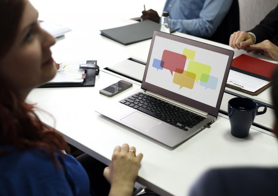 Free Image of Over the shoulder view of a laptop with speech bubbles 