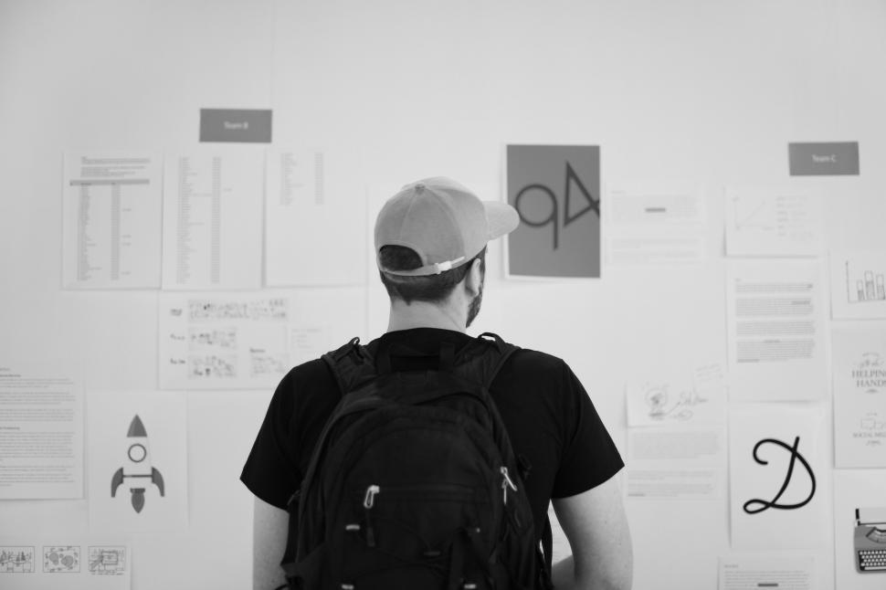 Free Image of View from behind young man and looking at the noticeboard 