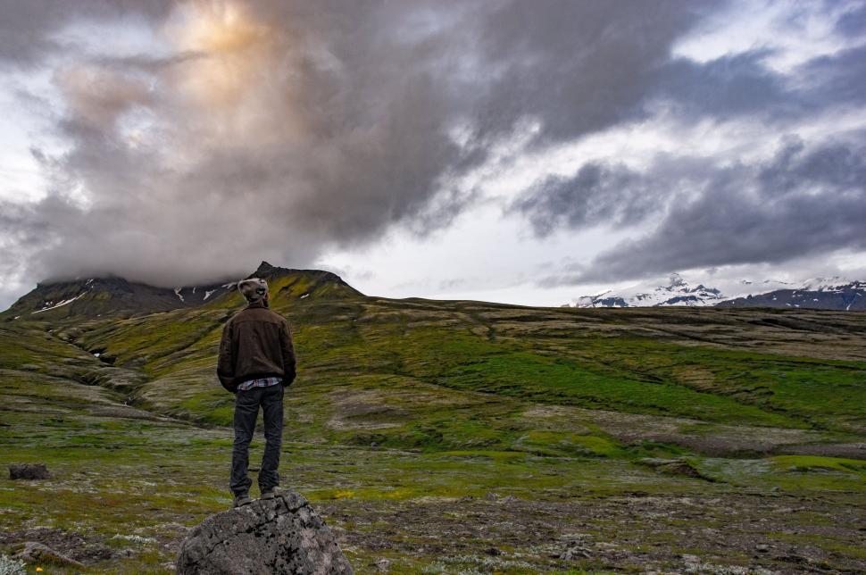 Free Image of Backside View of man standing on Rock 