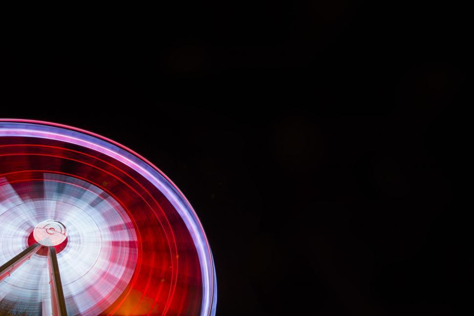 Free Image of Colorful spinning Ferris wheel at night 