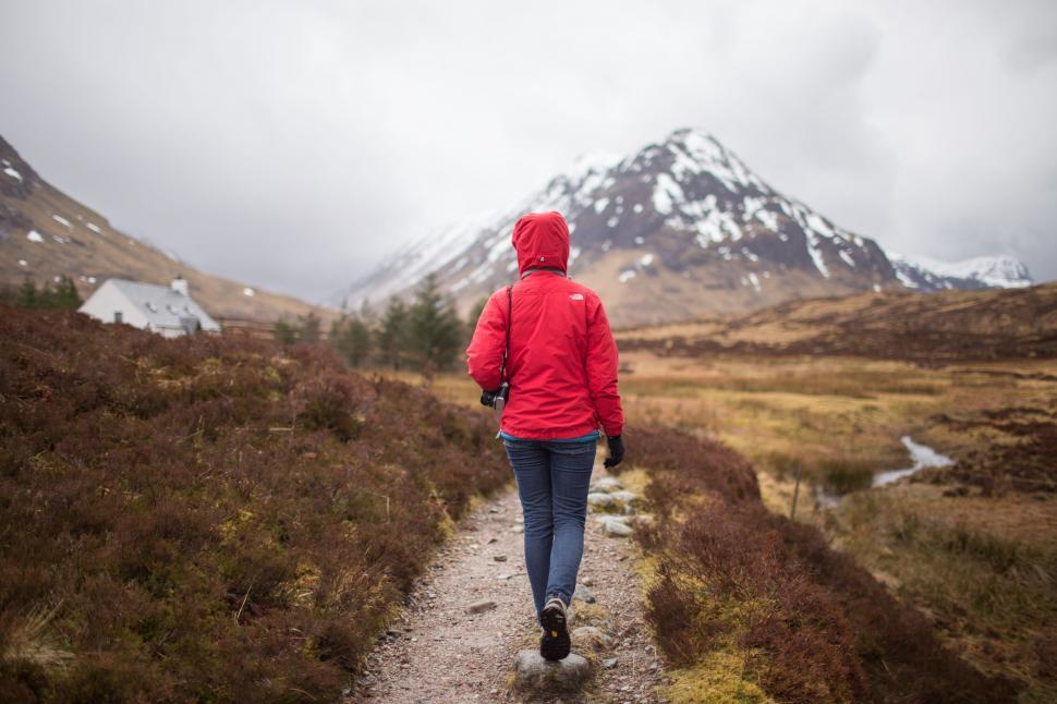 Free Image of Backside view of female hiker walking towards snow mountain 