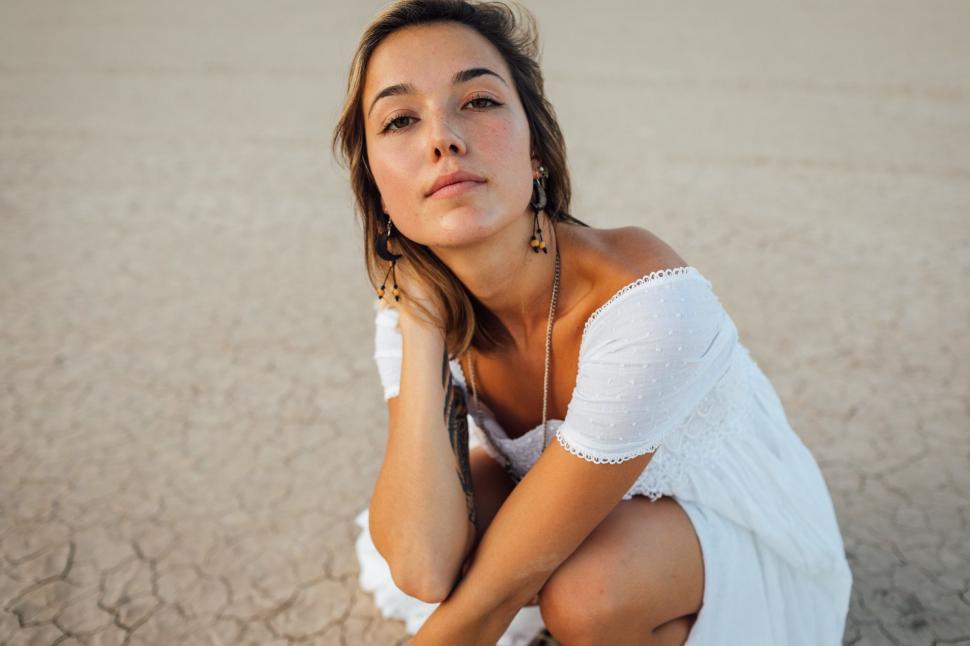 Free Image of Caucasian woman squats on dry cracked soil  