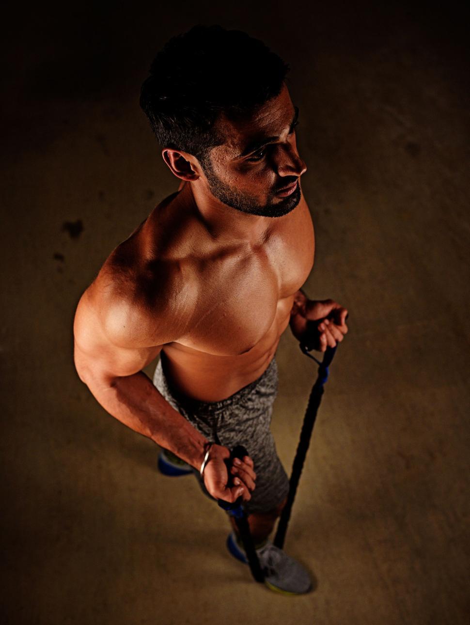 Free Image of Young Indian Man Pulling Up Expander 