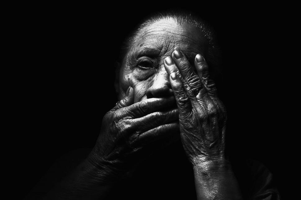 Free Image of Dark View of Old Woman with hands on face  
