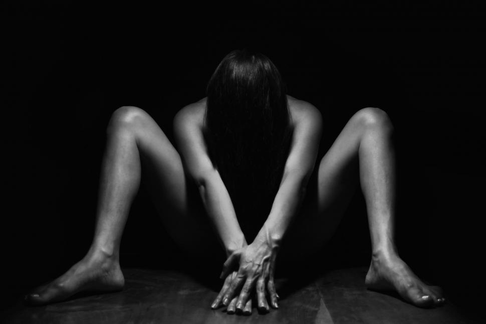 Free Image of Dark View of Naked Woman with hands in front on black background  