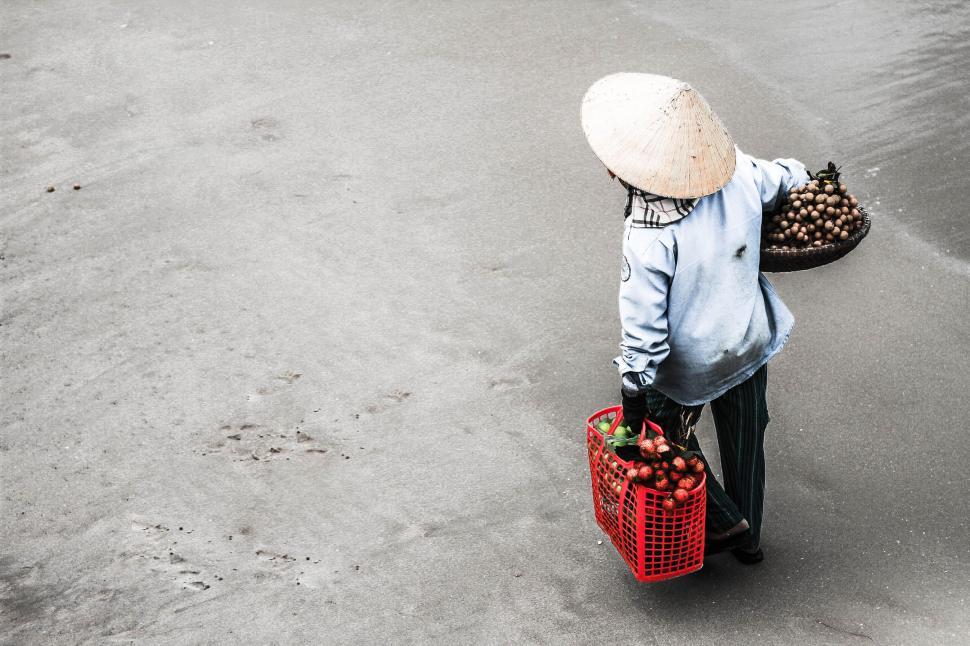 Free Image of Back view of Vietnamese Man Selling Fruits at the Beach  