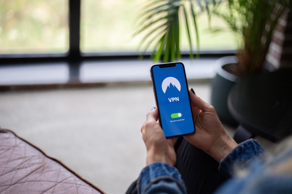 Free Image of Woman holding a smartphone in the office - over shoulder view 