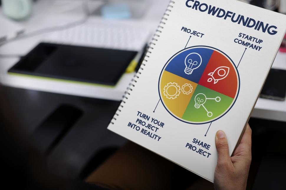 Free Image of Close up of a hand holding a project handbook on crowdfunding 