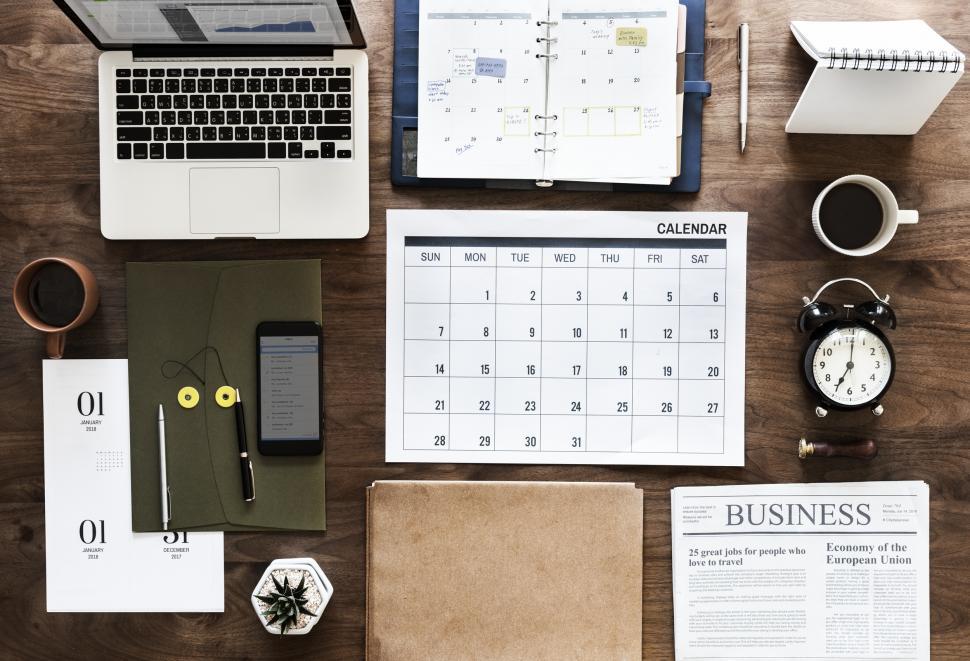 Free Image of Flat lay of a laptop and a coffee mug along with other items on the office table 