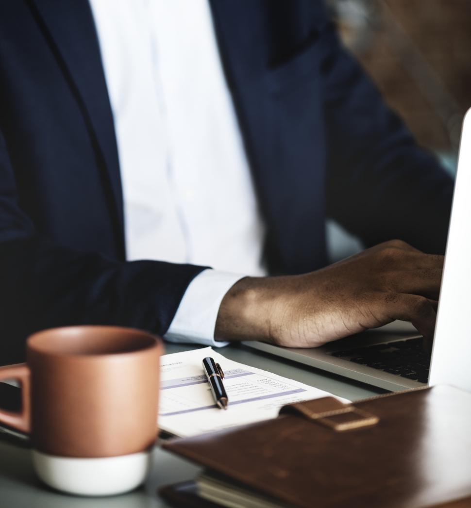 Free Image of Close up of a person working at a table on a laptop 