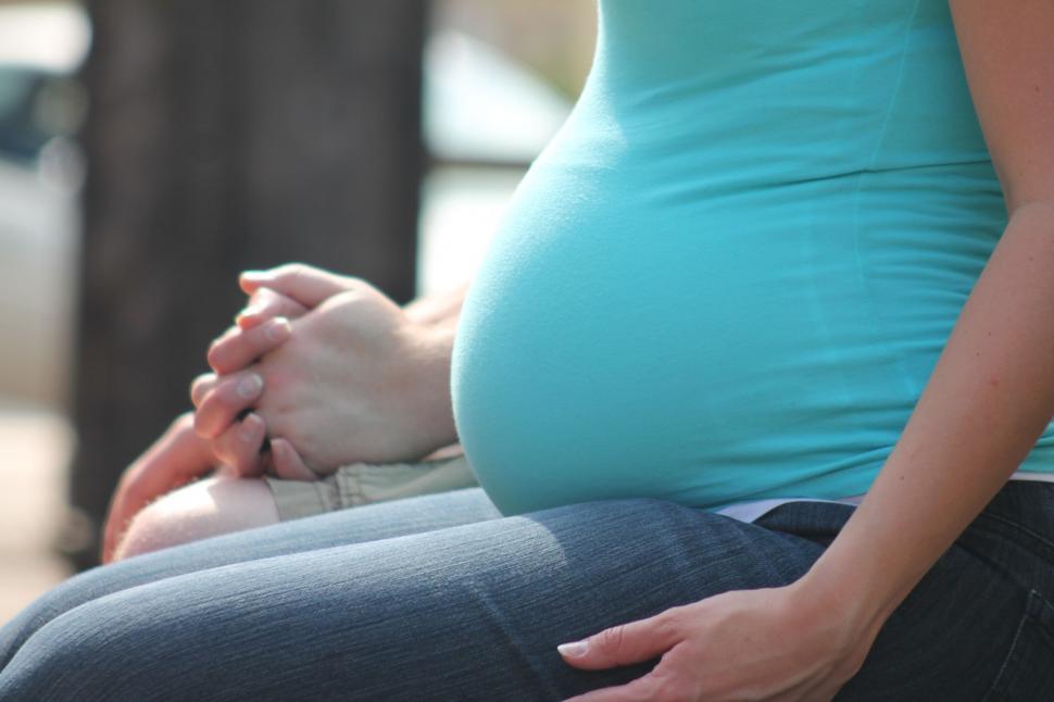 Free Image of Pregnant Woman Holding Hands  