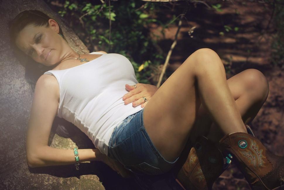Free Image of Woman relaxing on tree branch  