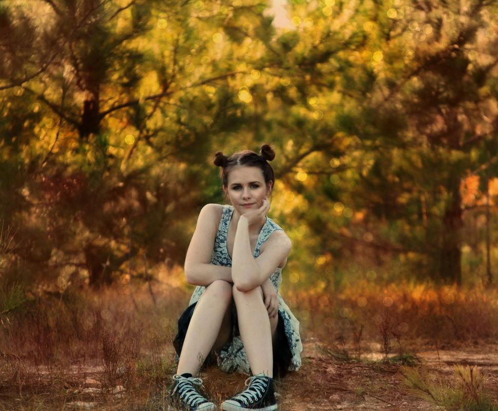 Free Image of Teenage Girl Sitting in the forest - Chin resting on hand  