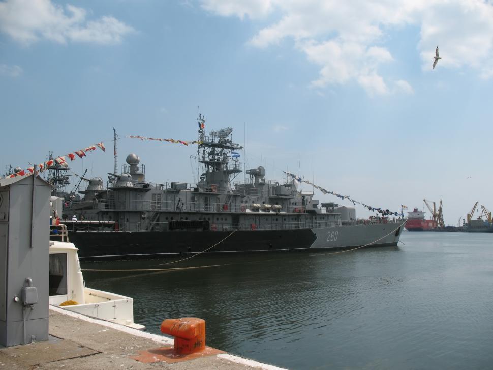 Free Image of A war ship at the dock open ocean in the background 