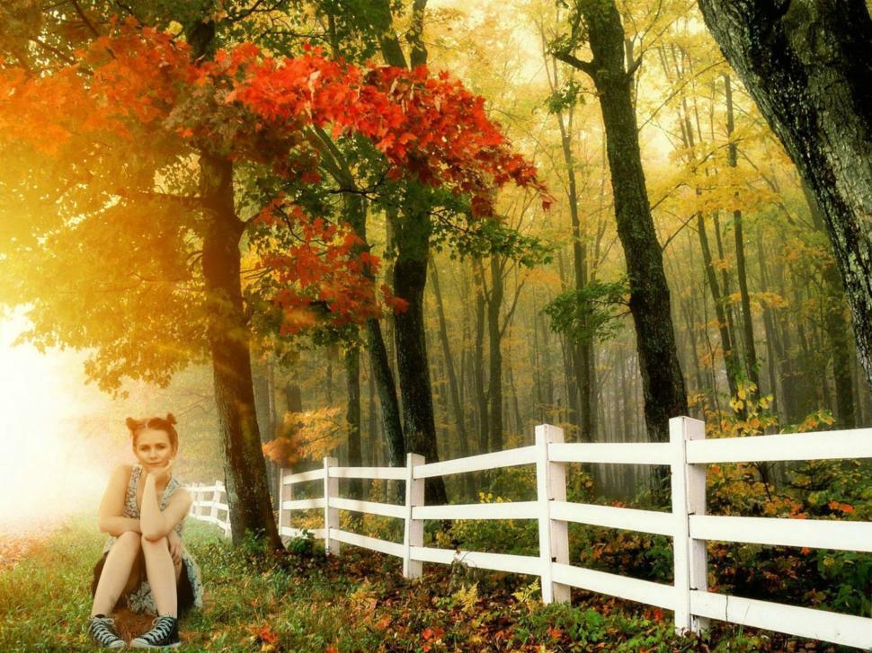 Free Image of Teenage Girl Sitting With Hand on Chin in the forest - looking at camera  
