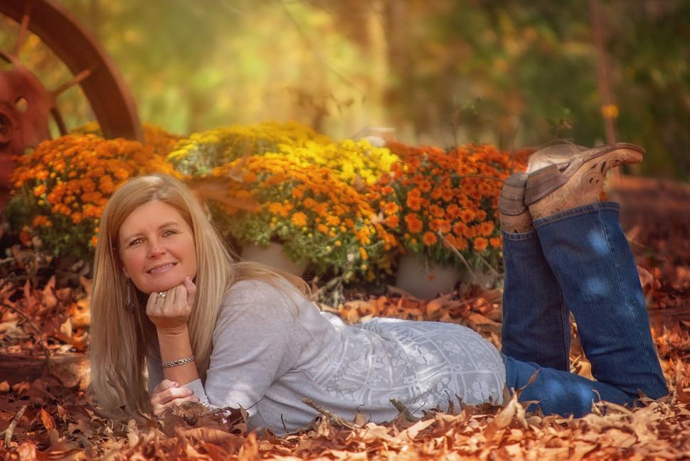 Free Image of Woman lying down on autumn leaves - hand on chin 