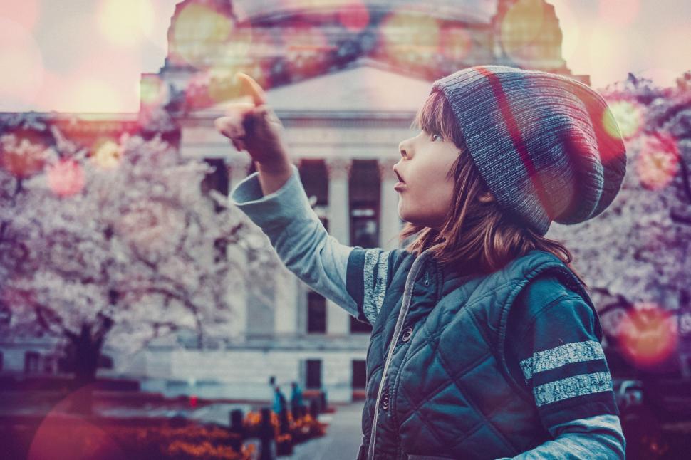 Free Image of Little Boy With Cherry Blossom Trees - pointing with finger and looking up 