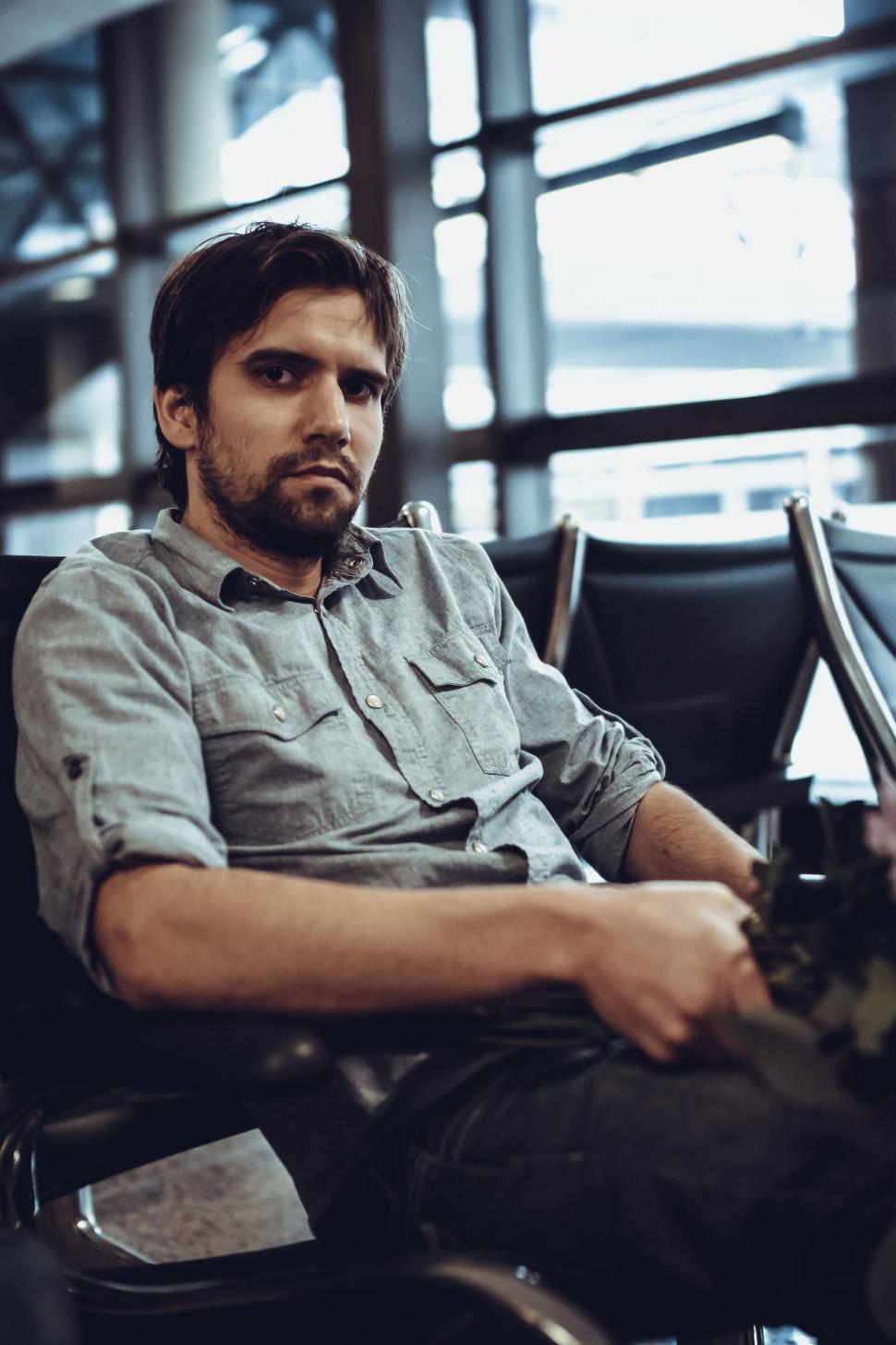 Free Image of Young Man waiting at the airport - looking at camera  