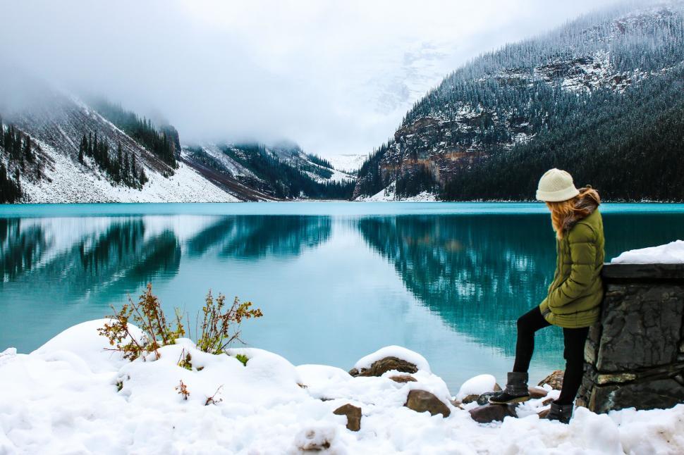 Free Image of Woman and Lake Louise With Snow Mountains During Foggy Winter Morning 