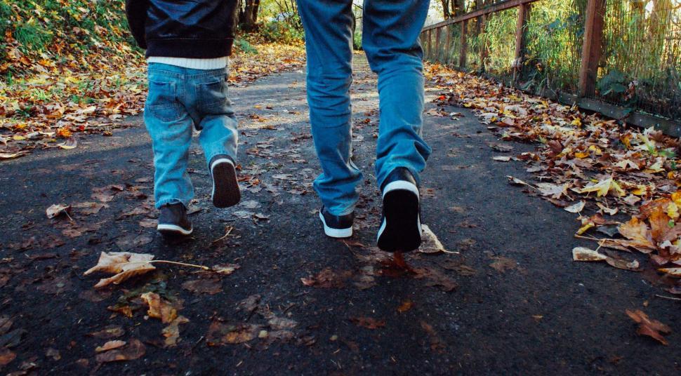 Free Image of Father and Son on pathway with fallen leaves - face not seen  