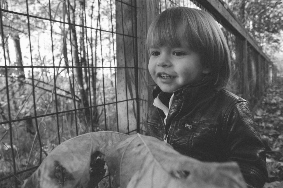 Free Image of Smiling Little Boy and Wire Fence - B&W 