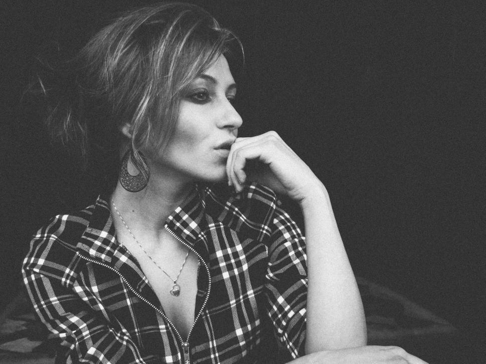 Free Image of Stylish woman sitting with hand on chin  