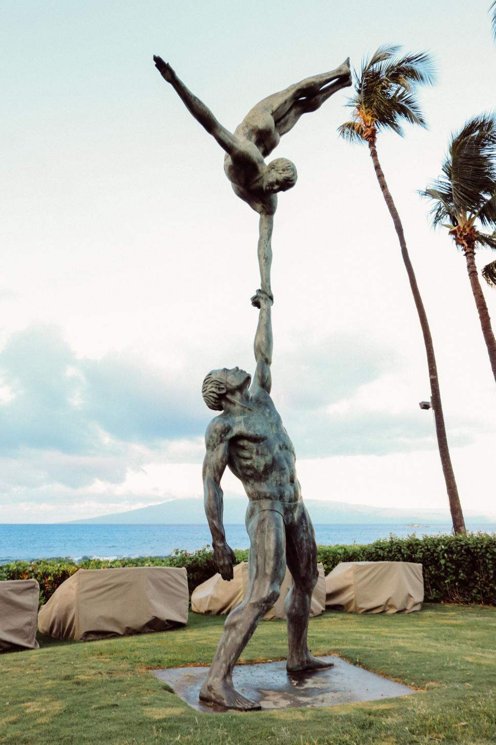 Free Image of The Acrobats statue with ocean and sky in the background  