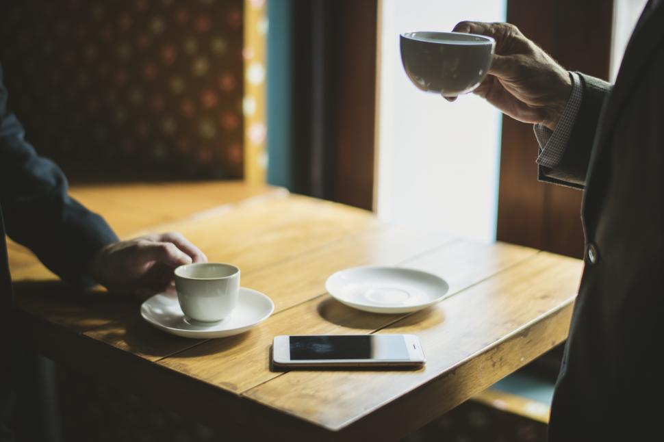 Free Image of Two anonymous people drinking coffee at a cafe 
