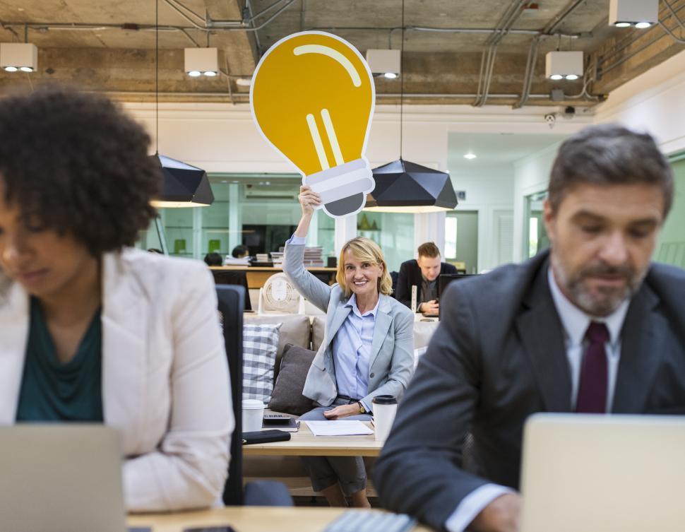 Free Image of A woman holding a lightbulb idea shaped cardboard cutout over her head 