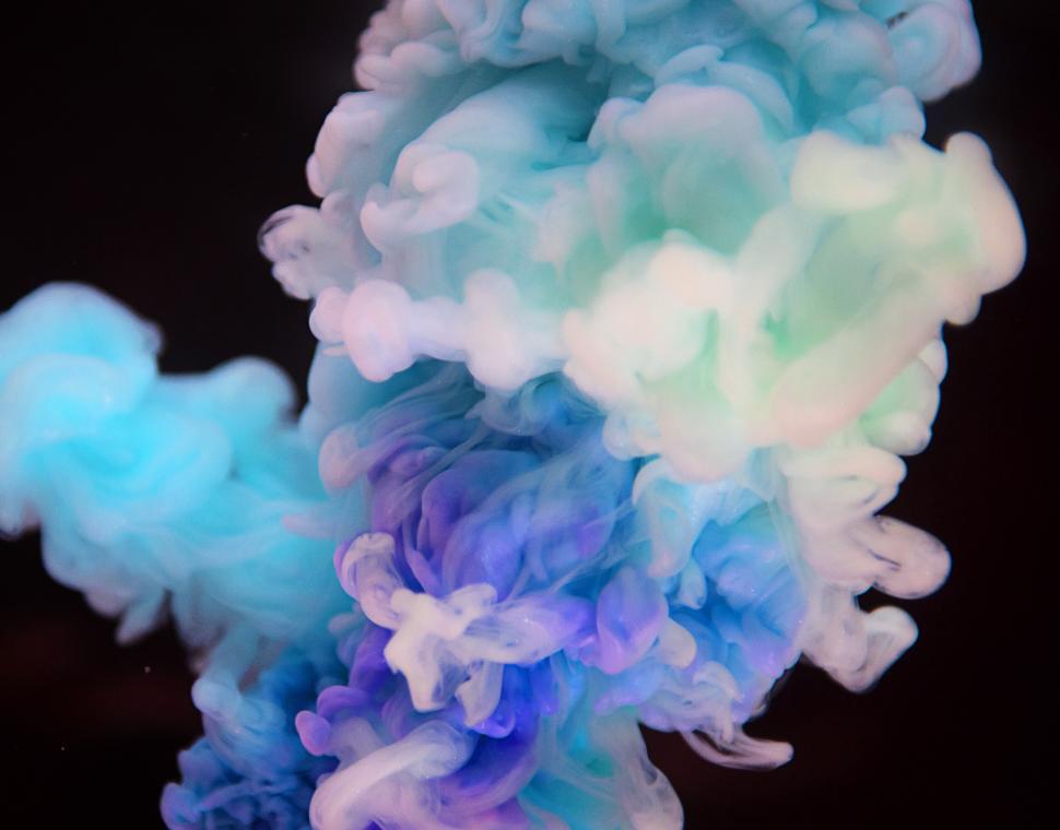 Free Image of An abstract smokey pattern of blue, green and purple ink swirling in water 