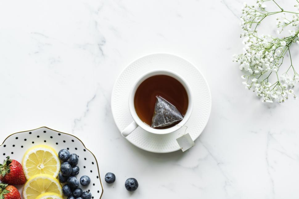 Free Image of Flat lay of fruit salad in a plate and a cup of tea 