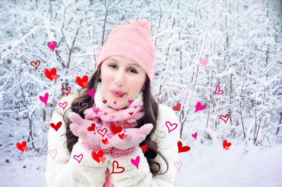 Free Image of Woman Blowing Heart Kisses in Snow - Looking at camera  