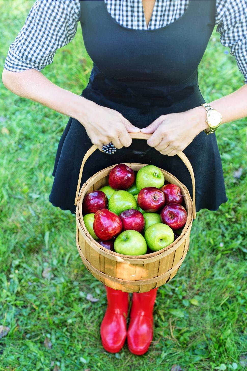 Free Image of Woman in red shoes with basket of apples  