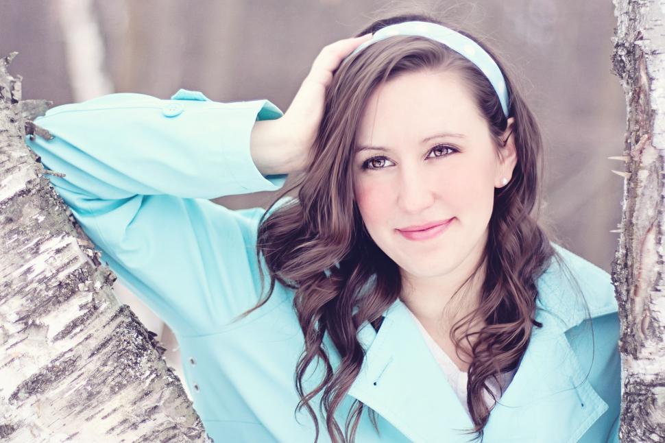 Free Image of Brunette Woman Posing with Tree Trunk - Looking away 